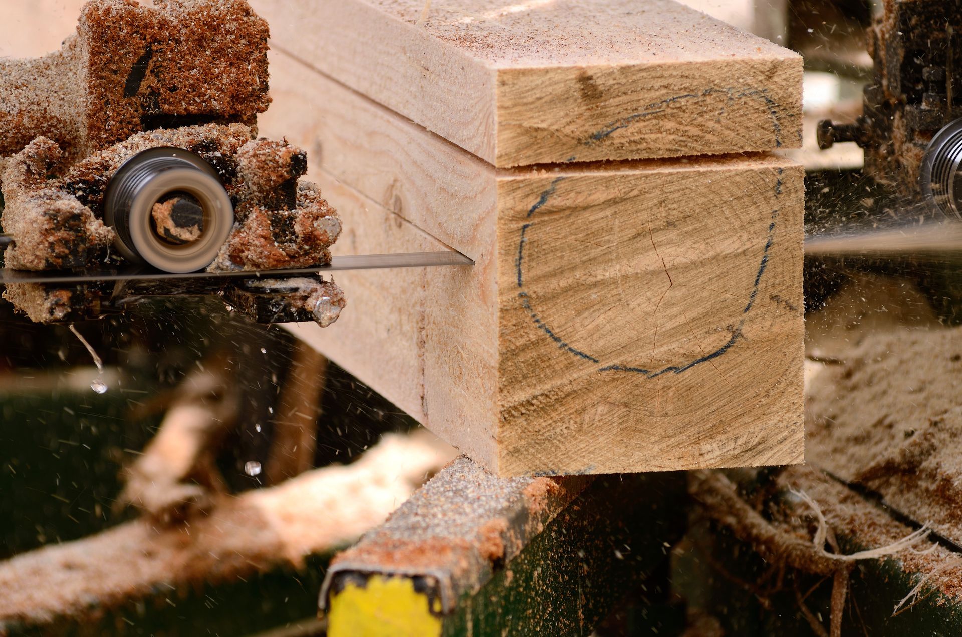 A machine is cutting a piece of wood with a smiley face drawn on it.