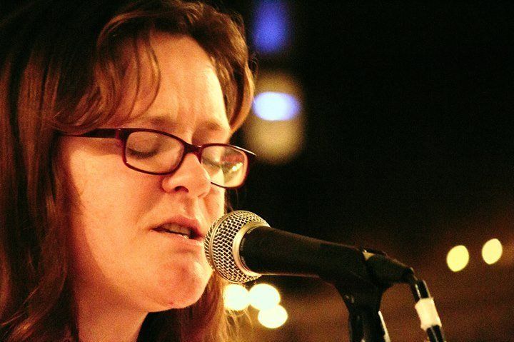 Face of a woman singing into a microphone