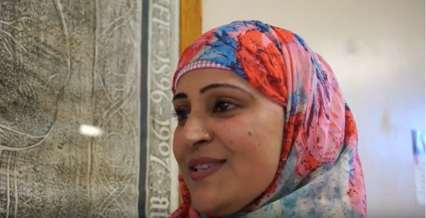 A head and shoulders photo of a smiling woman wearing a hijab