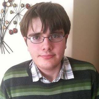 A head and shoulders photo of Phil who has brown hair and is wearing glasses.