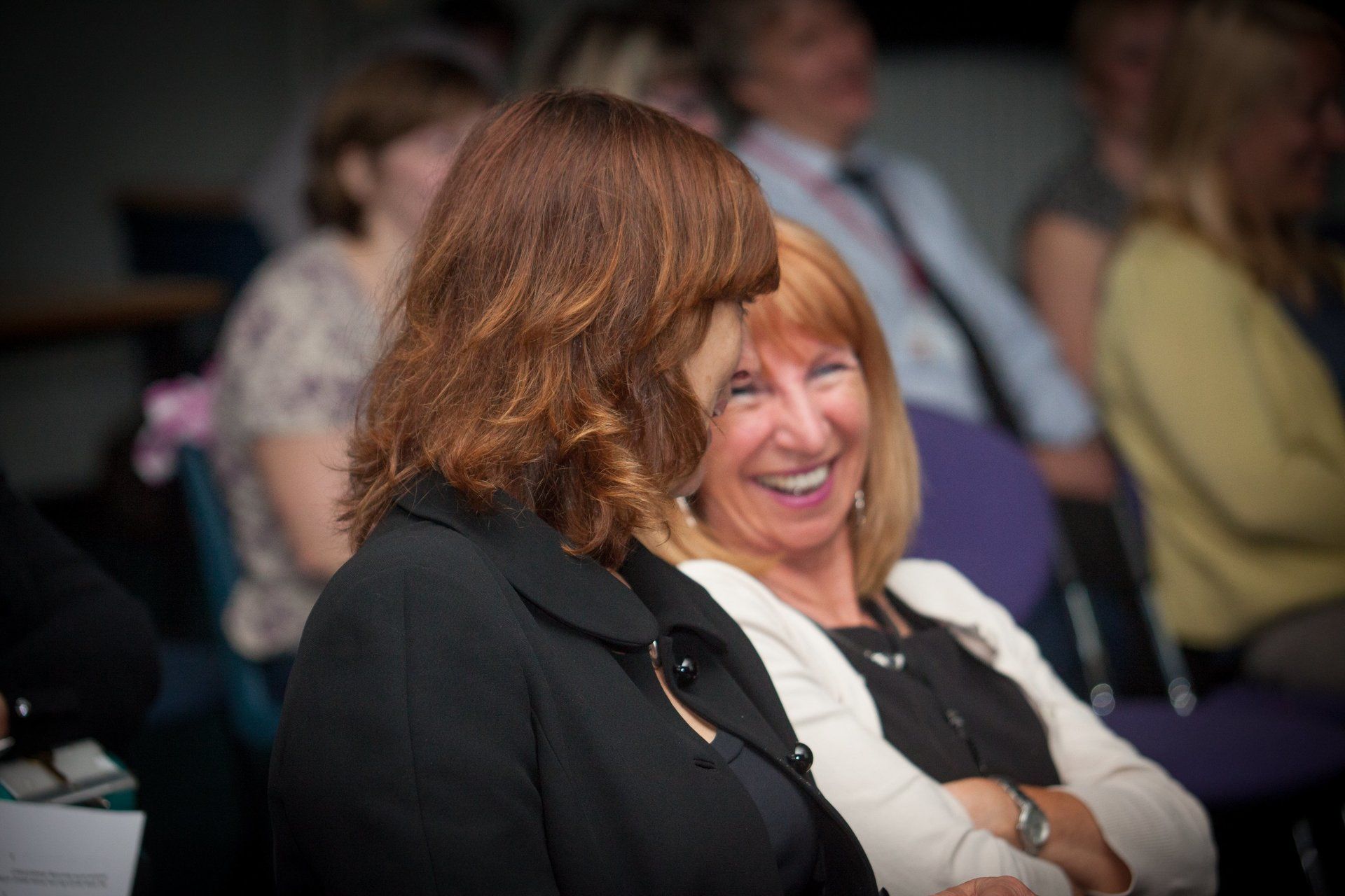 Two  smilingwomen sitting and looking at each other