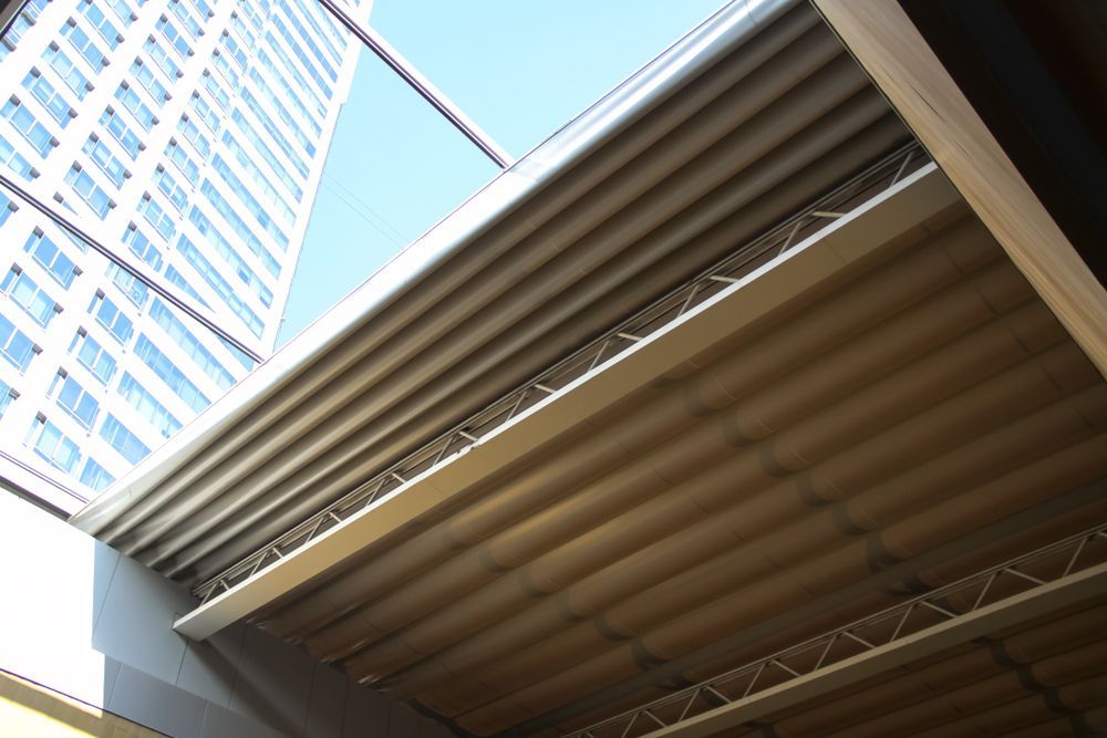 Looking Up at a Beige Corrugated Ceiling Under a Bright Blue Sky — CP Roofing in Old Bar, NSW