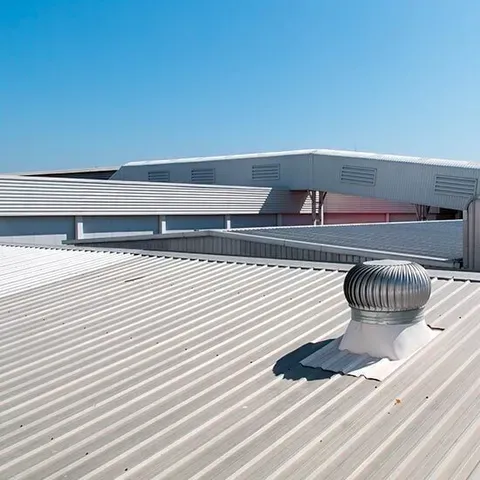 A Metal Roof With A Wind Turbine On Top Of It — CP Roofing in Wingham, NSW