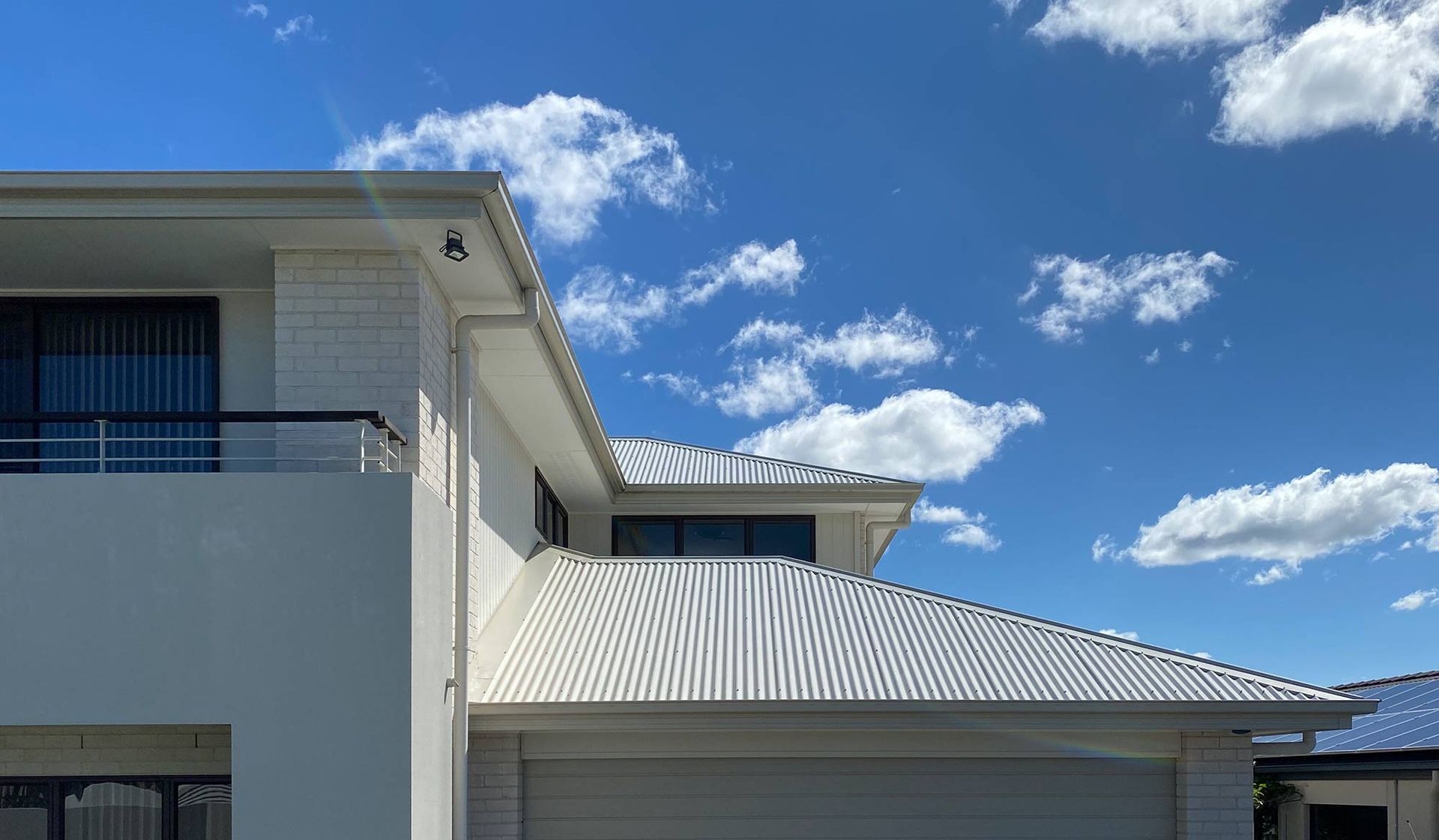 A White House With A Blue Sky And Clouds In The Background — CP Roofing in Old Bar, NSW