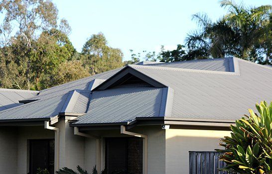 A house with a gray roof and trees in the background
