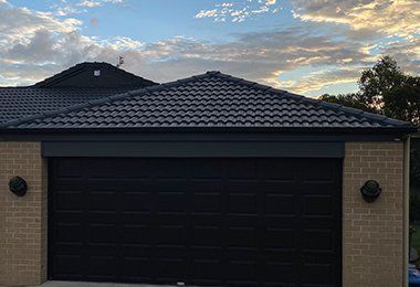 House With a Black Garage Door and a Black Roof — CP Roofing in Old Bar, NSW