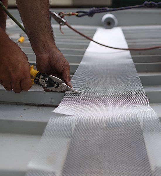 A Person Is Cutting A Piece Of Metal With A Pair Of Scissors — CP Roofing in Forster, NSW