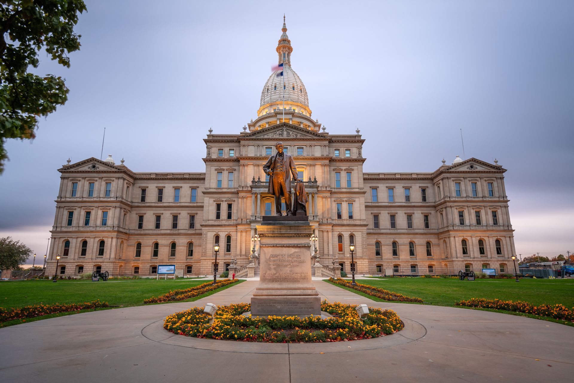 Michigan State Capitol Building with statue in front.