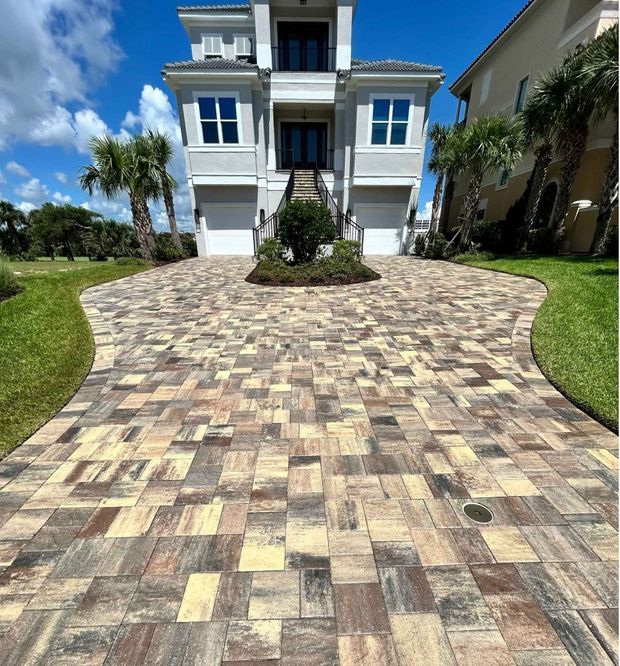 A driveway with perfectly sealed pavers leading to a two-story house with two garage bays in Grand Haven neighborhood in Palm Coast, Flagler County, FL.