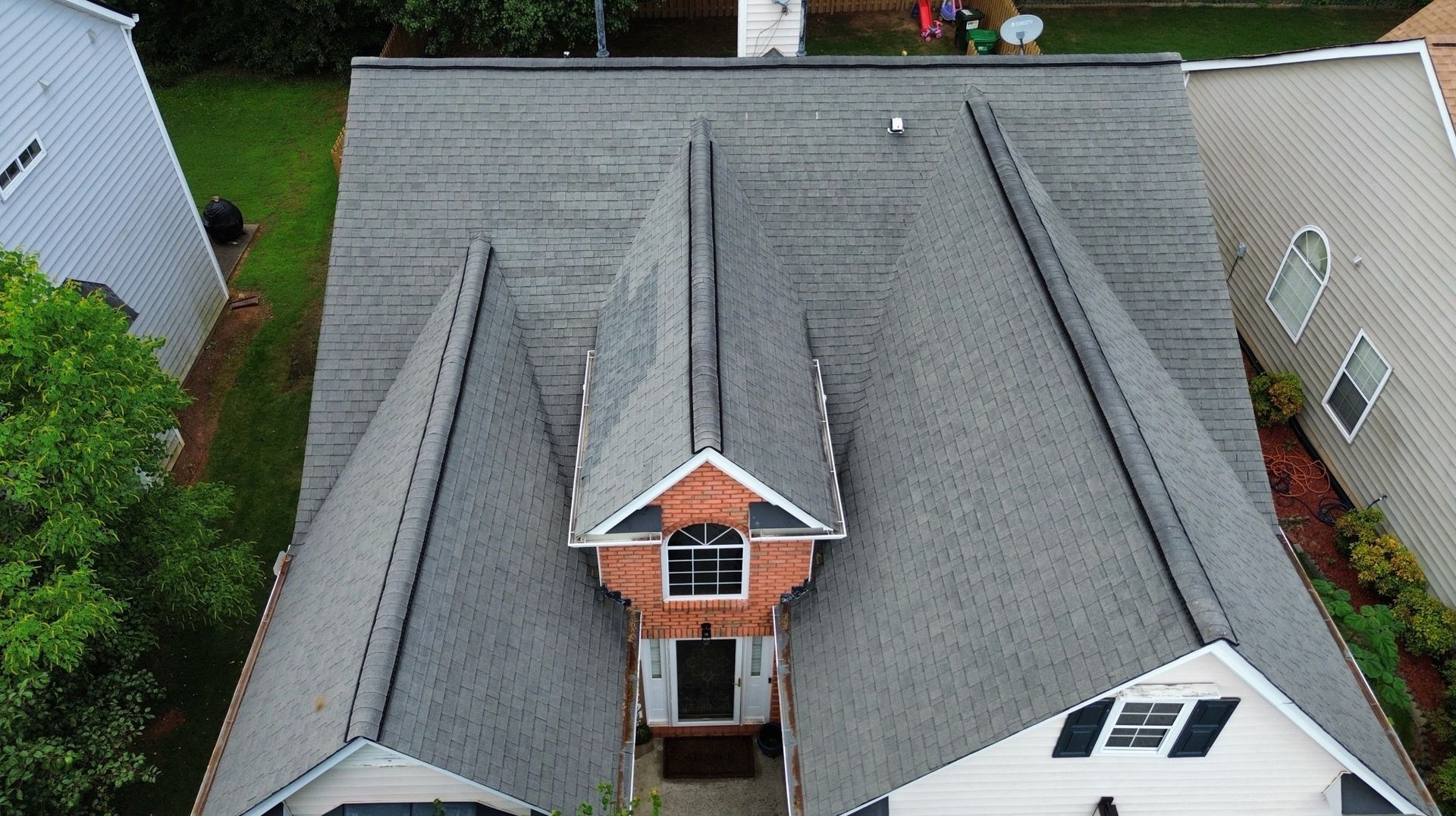 Overhead view of a house with a gray roof, brown accents, and a small front gable.