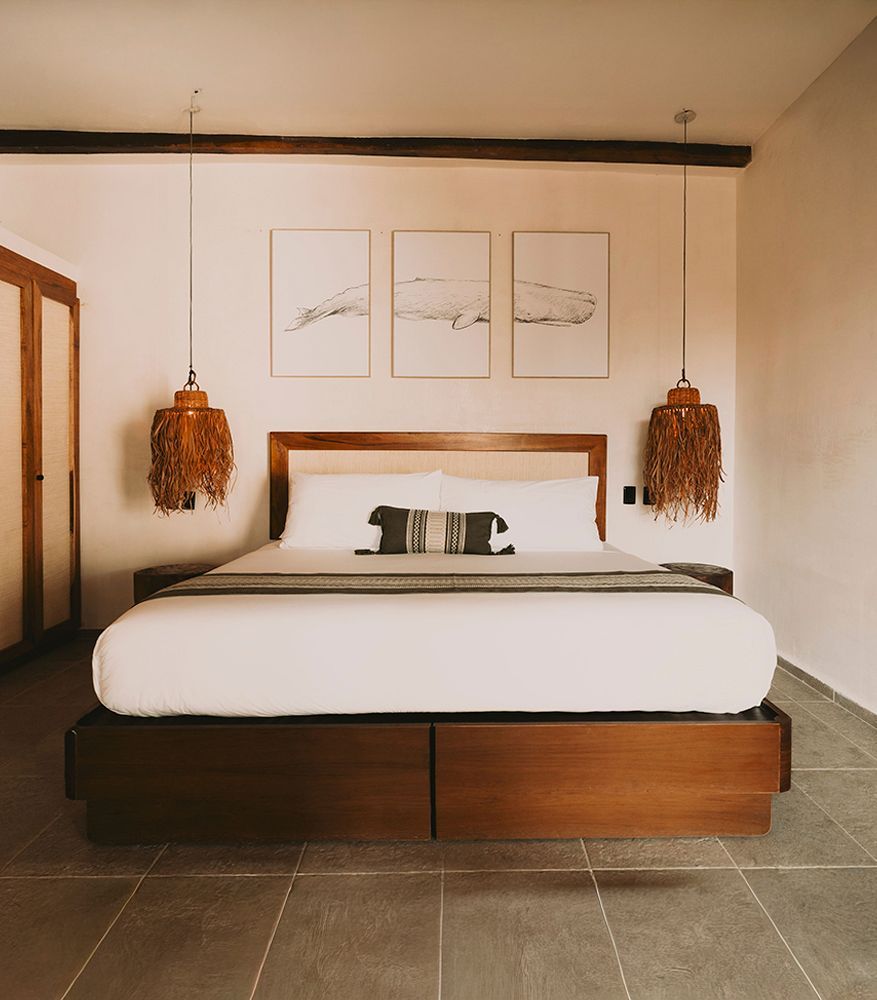 Bedroom with wooden bed, exposed beams, and decorative lighting.