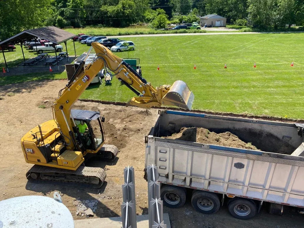An excavator is loading dirt into a dump truck.