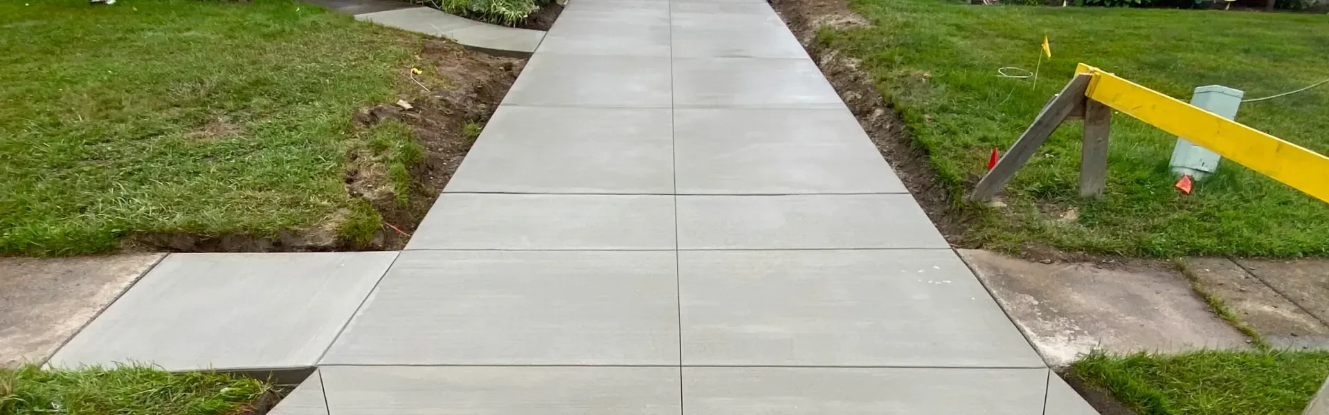 A concrete walkway is being built in a yard.