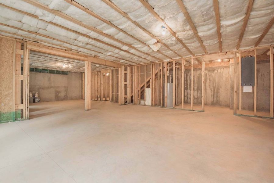 Unfinished basement with wood framing, insulation, and concrete floor.