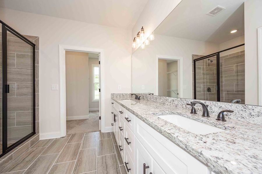 Modern bathroom with gray tile, a double vanity, and a large mirror.