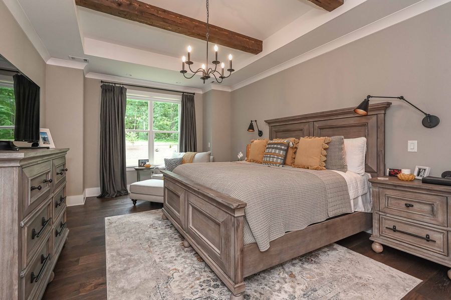Bedroom with gray walls, wooden furniture, bed, rug, and dark drapes near a window.