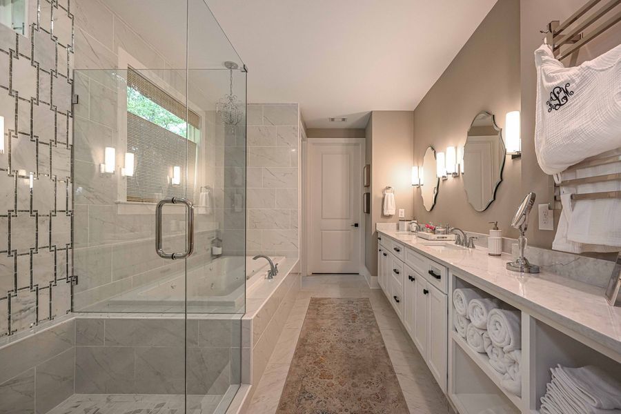 Luxurious bathroom with a tub, vanity, and glass shower. Neutral tones and modern design.