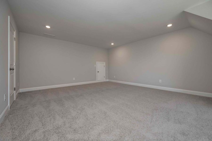 Empty room with light gray walls and carpet, white trim, and recessed lighting.