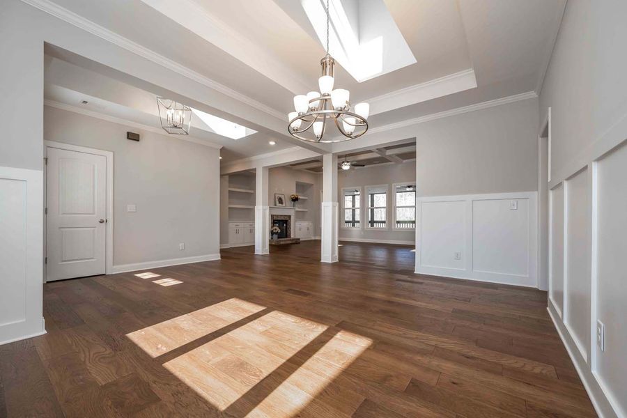 Bright, open room with hardwood floors, white trim, and modern light fixtures.