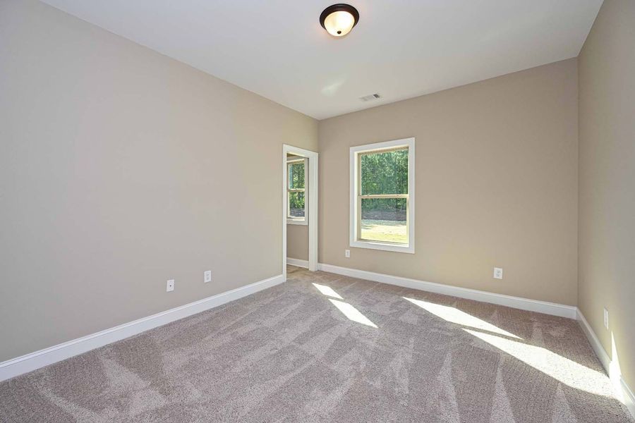 Empty room with beige walls, white trim, carpet, and a window.