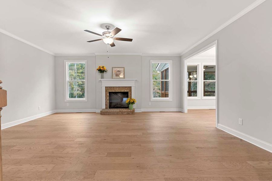Spacious living room with hardwood floors, fireplace, and natural light.