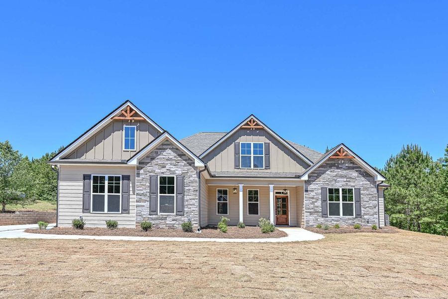 Ranch-style home with stone and siding exterior under a clear blue sky.