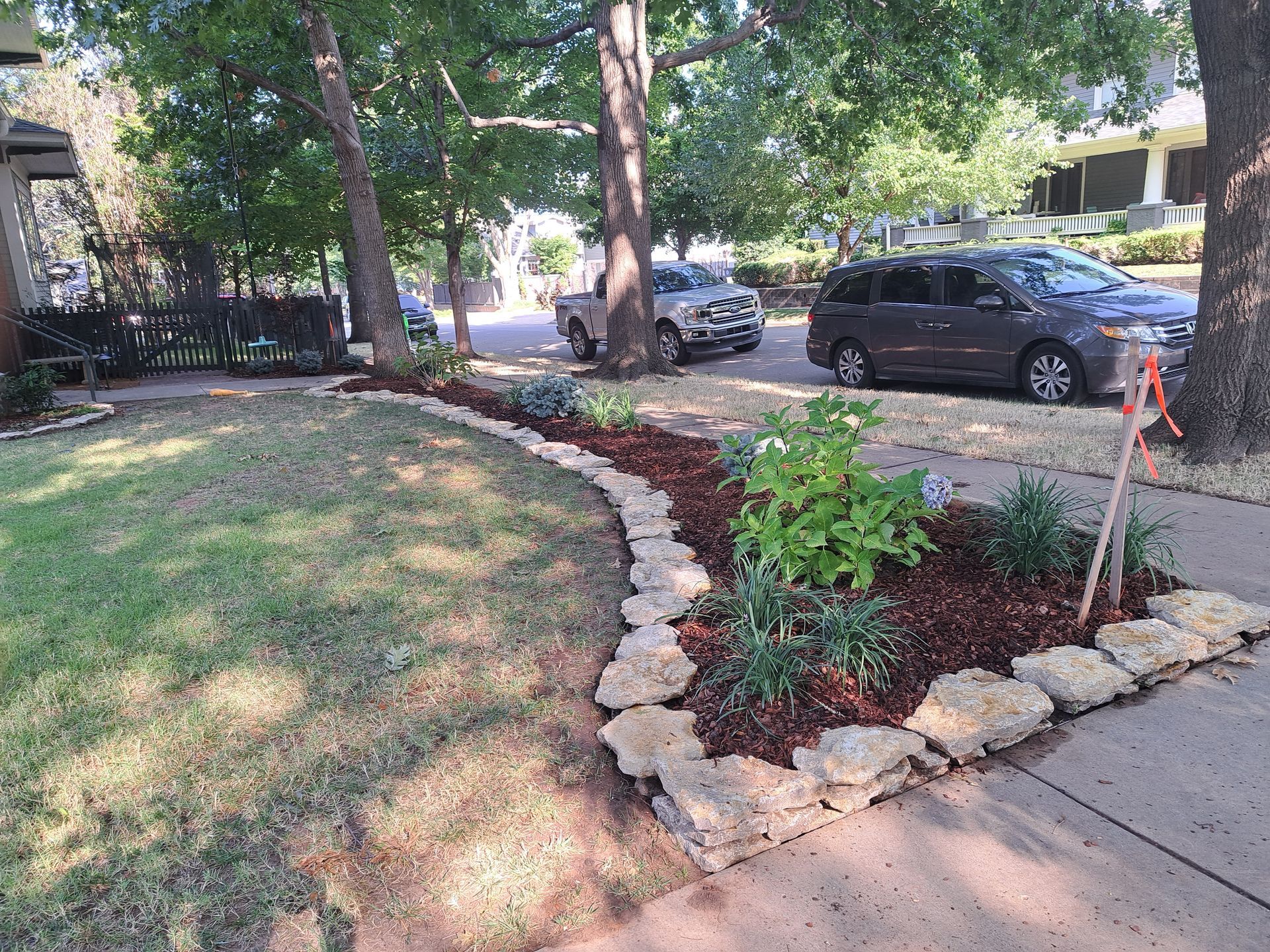 A van is parked in a driveway next to a lush green yard.