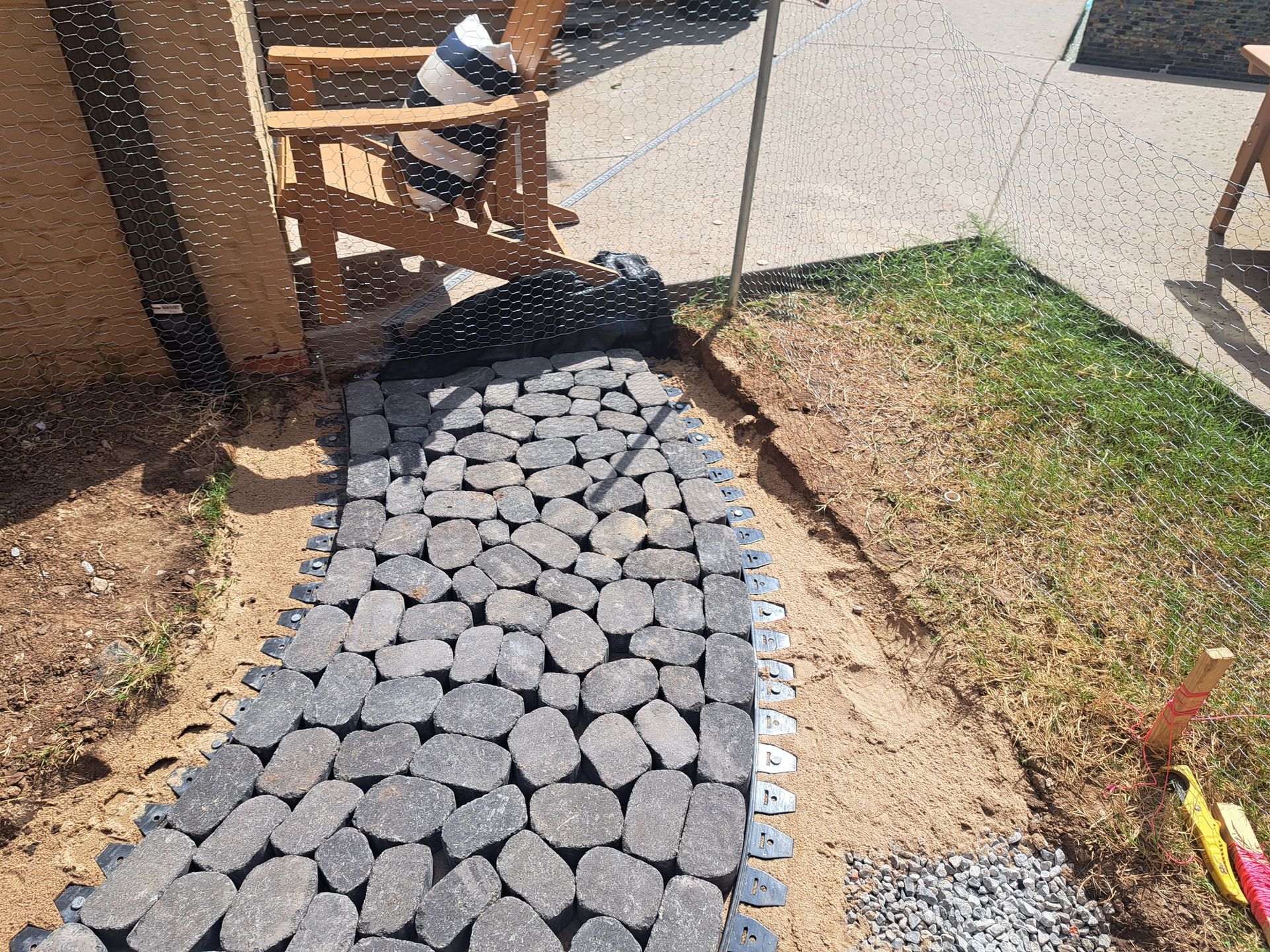 A stone walkway is being built in a backyard.