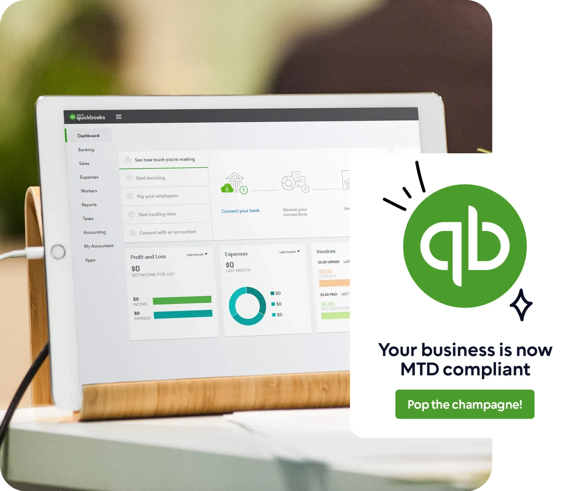 Tablet displaying the QuickBooks dashboard with charts and options for invoicing, expenses, and taxes. A celebratory message appears alongside the QuickBooks logo, reading 'Your business is now MTD compliant – Pop the champagne!'