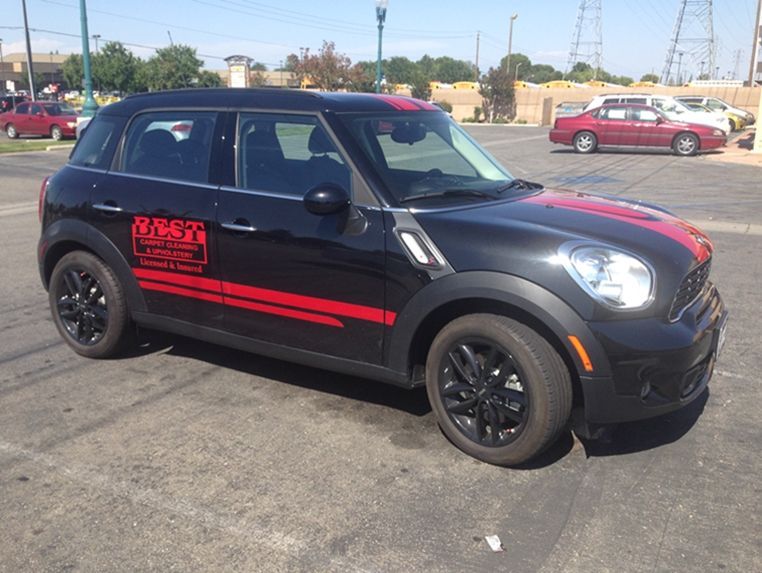 A black mini cooper is parked in a parking lot