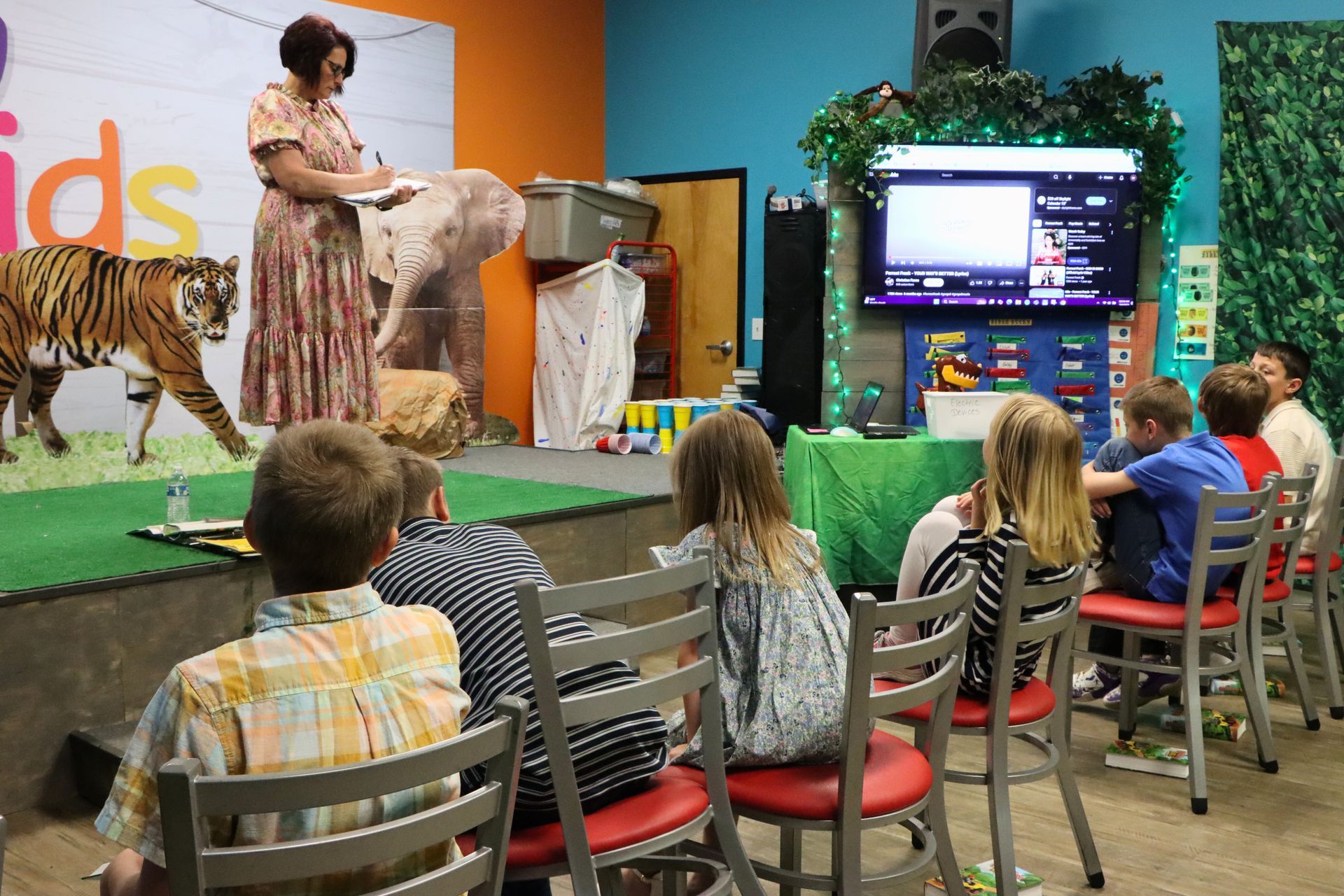 A woman is giving a presentation to a group of children