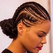 A woman with braids in her hair is wearing a bun.