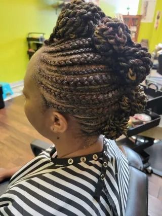 A woman is sitting in a chair with her hair in a bun.