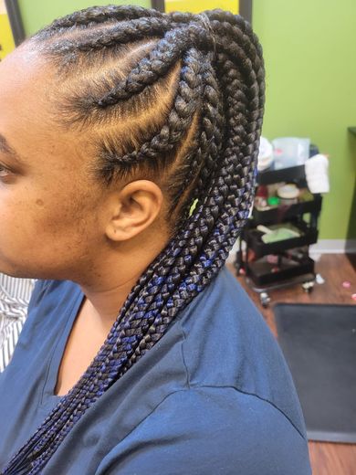 A woman with braids in her hair is wearing a blue shirt.