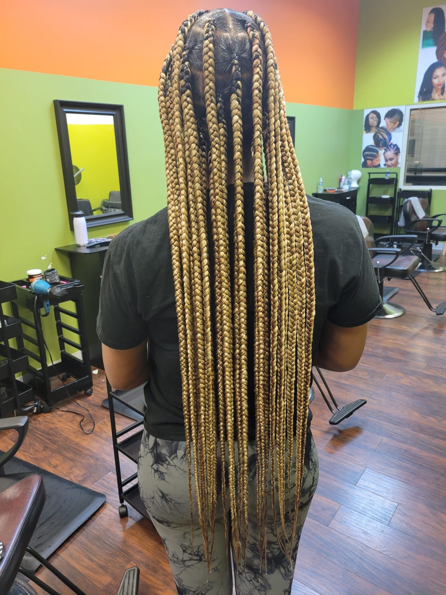 A woman with very long braids is standing in a salon.