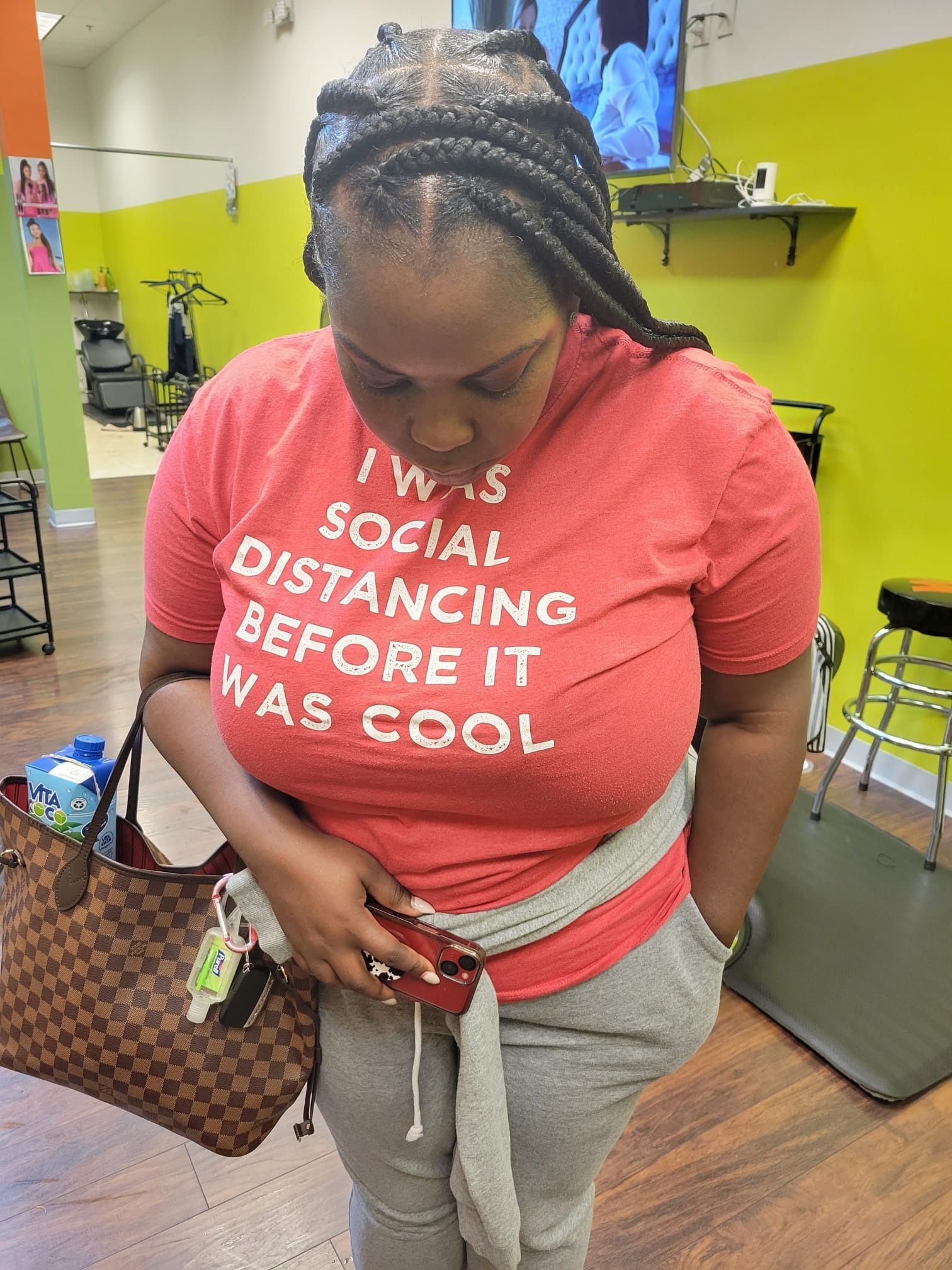 A woman is wearing a red t-shirt that says `` i was social distancing before it was cool ''.