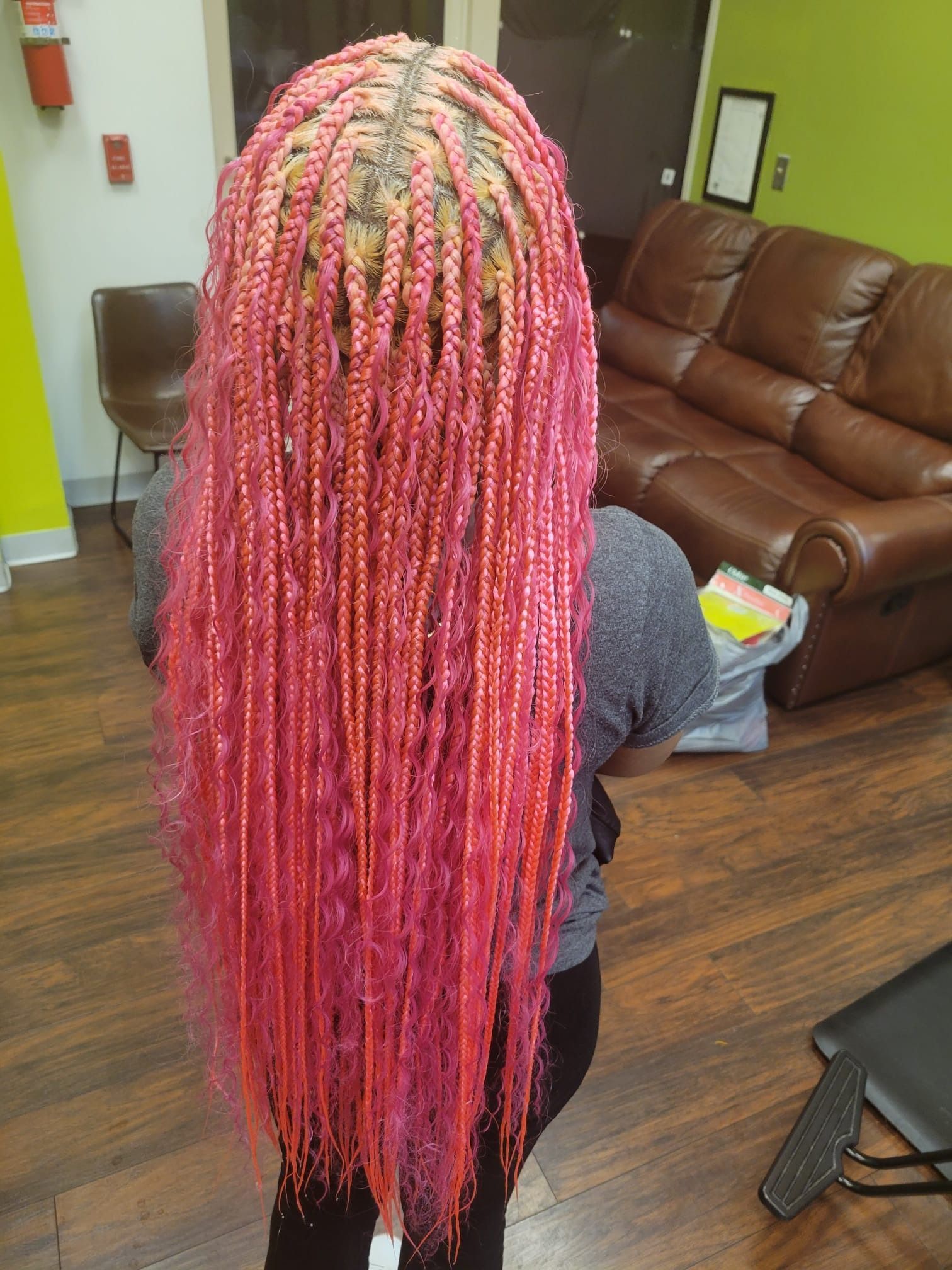A woman with pink braids is standing in a living room.