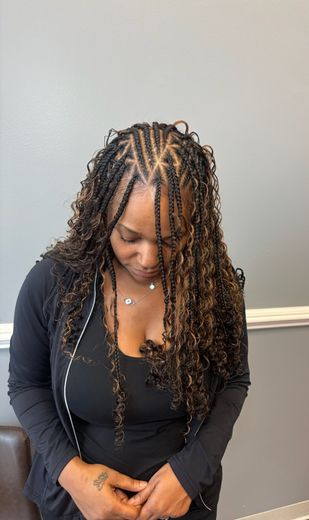 A woman with braids in her hair is wearing a blue shirt.