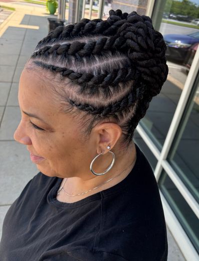 A woman with very long braids is standing in a salon.