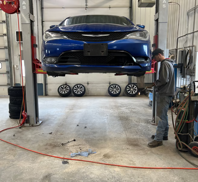Blue car on lift in our garage | Itasca Automotive