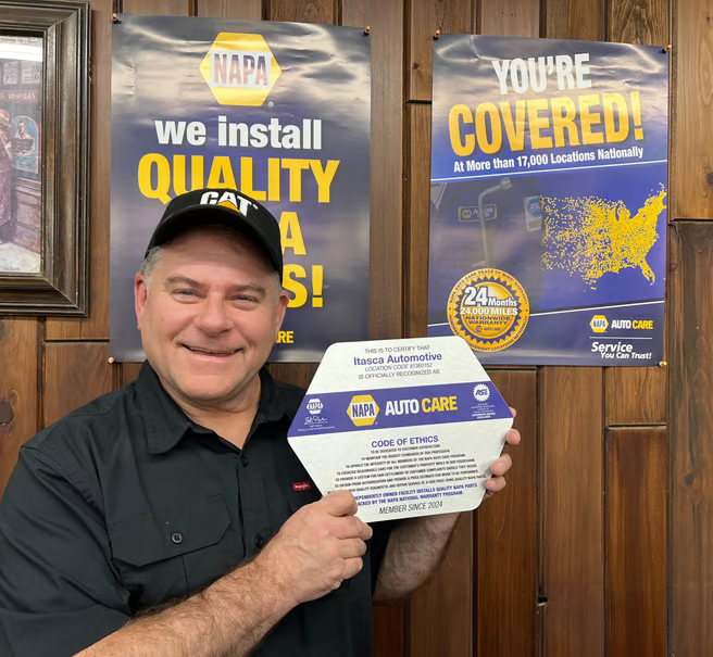 A person holing a NAPA Auto Care Code of Ethics | Itasca Automotive