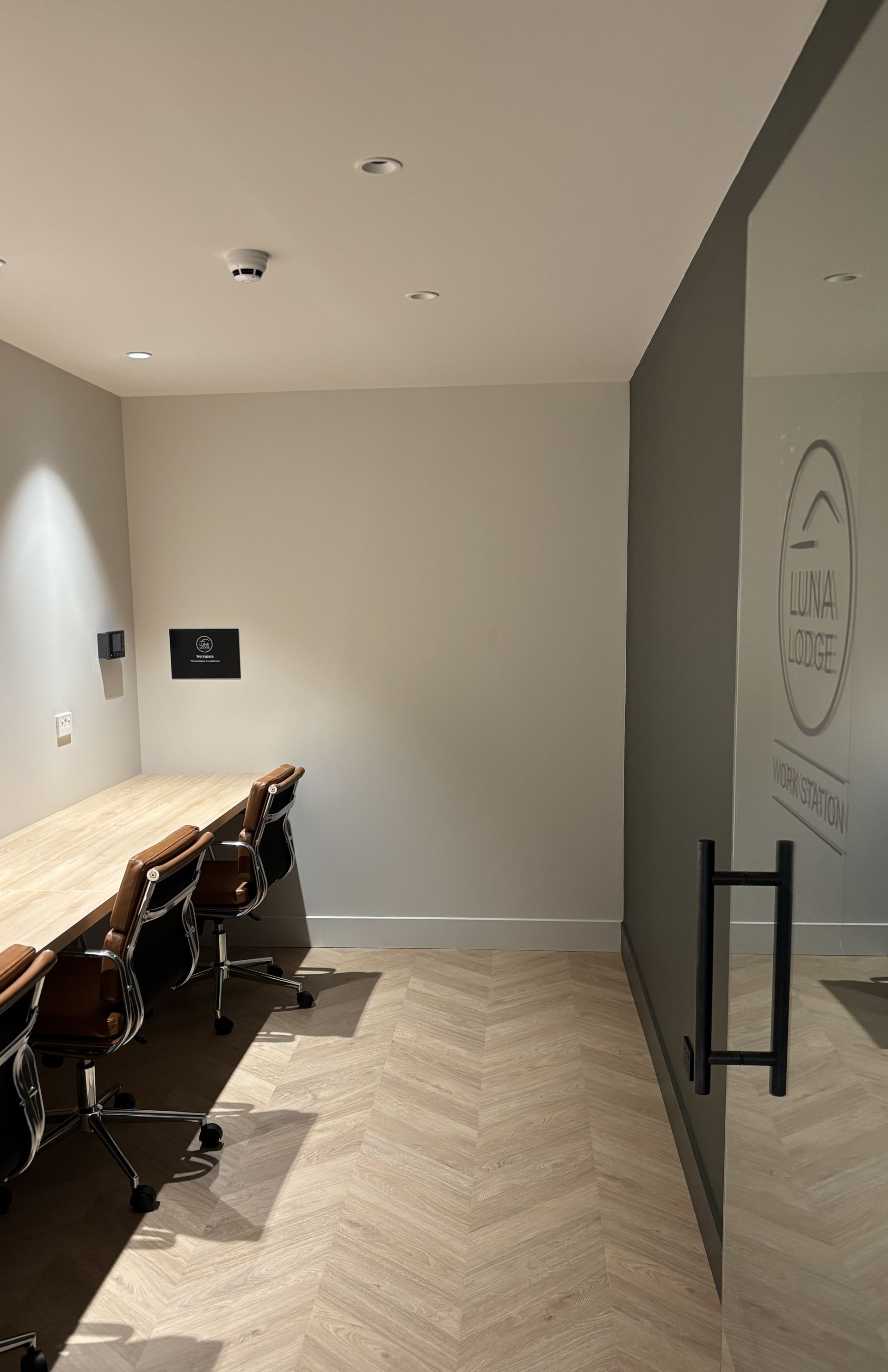 A laptop computer is sitting on a wooden table in front of a window.