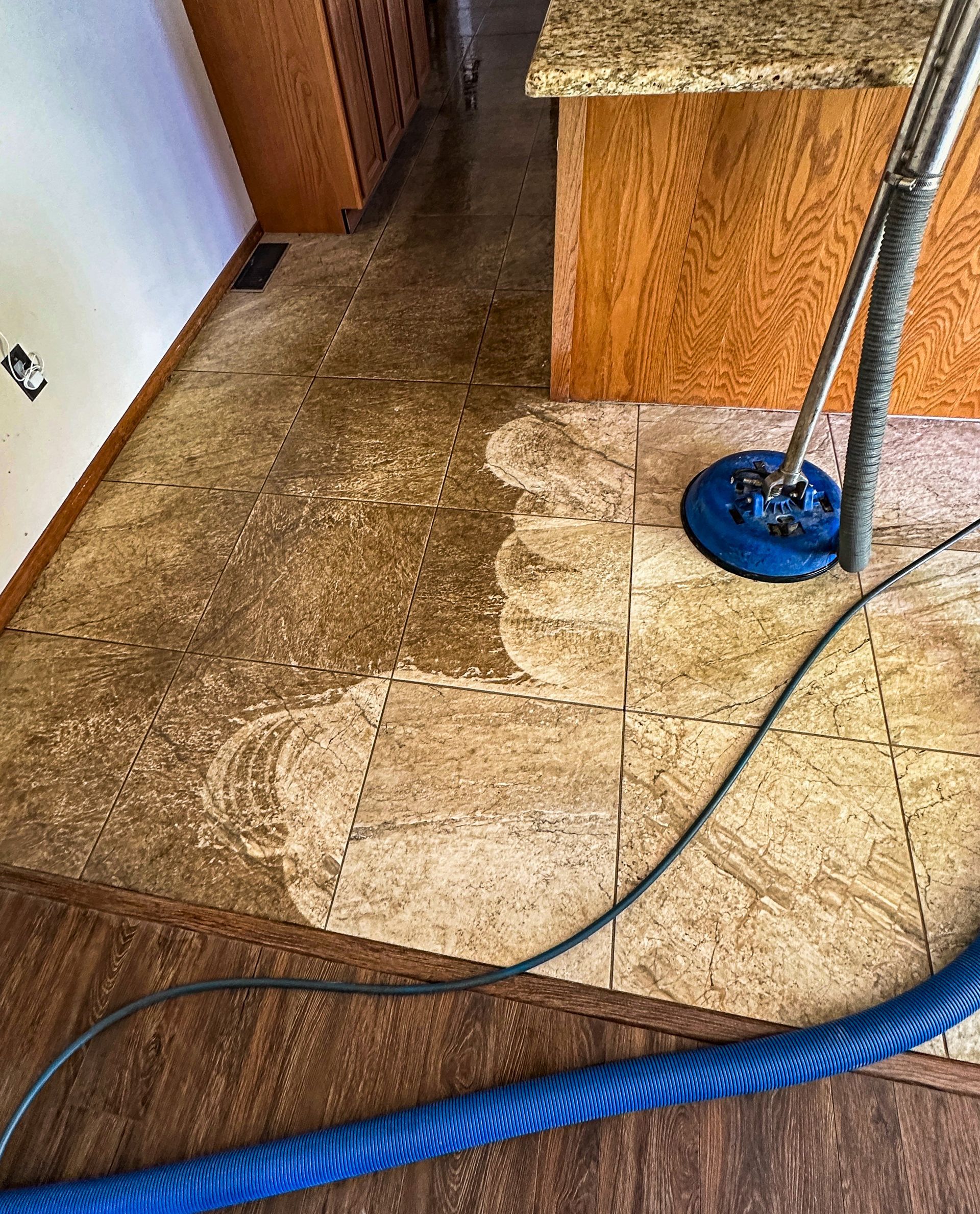A man is applying grout to a tiled wall with a spatula.