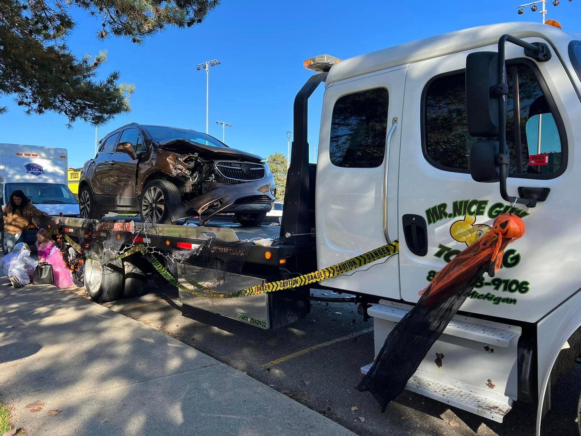 A tow truck with a damaged car on the back of it