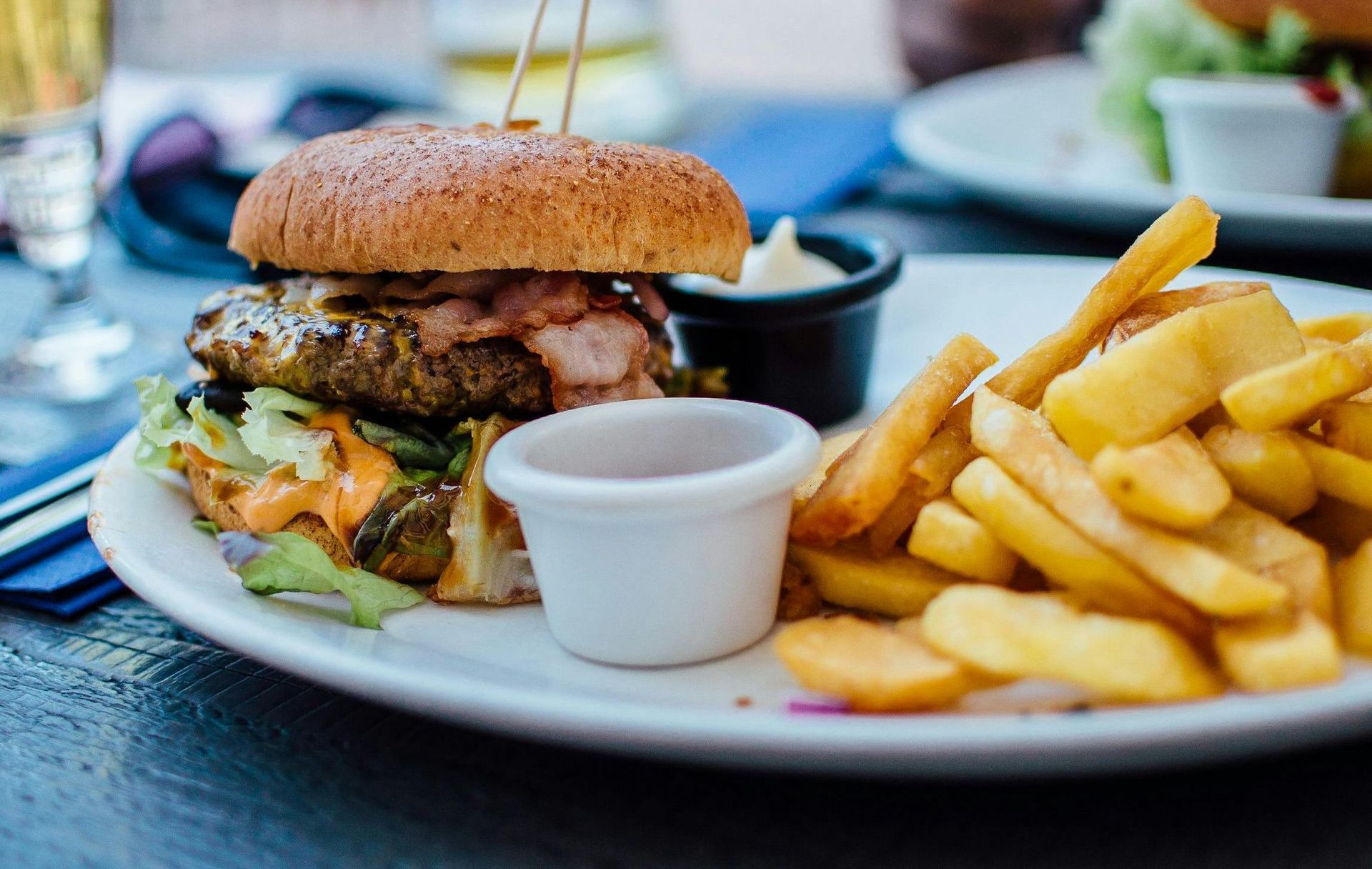 A plate of food with a hamburger and french fries on a table.