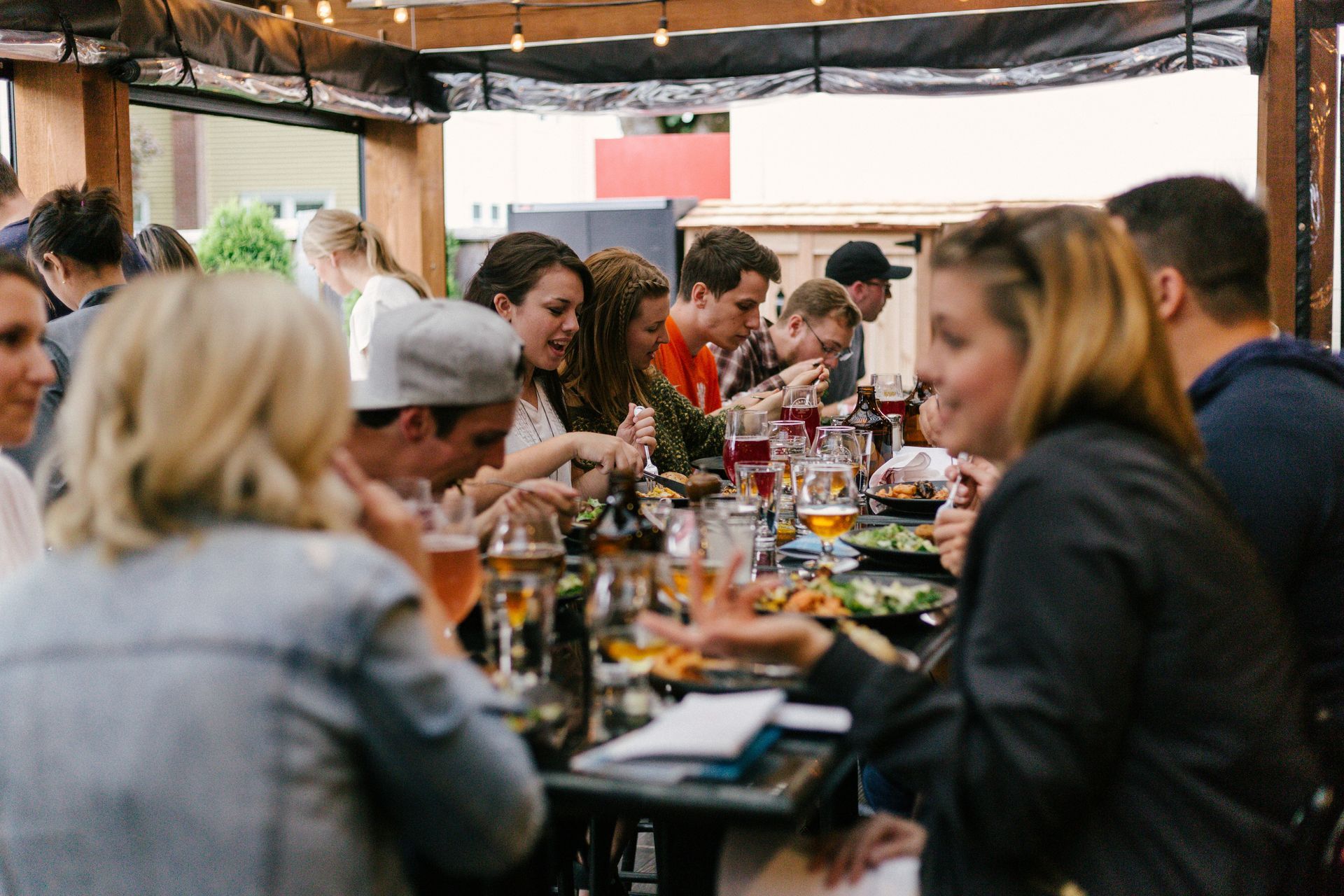 A group of people are sitting at tables in a restaurant eating food.