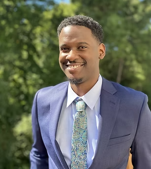 A man in a suit and tie is smiling for the camera.