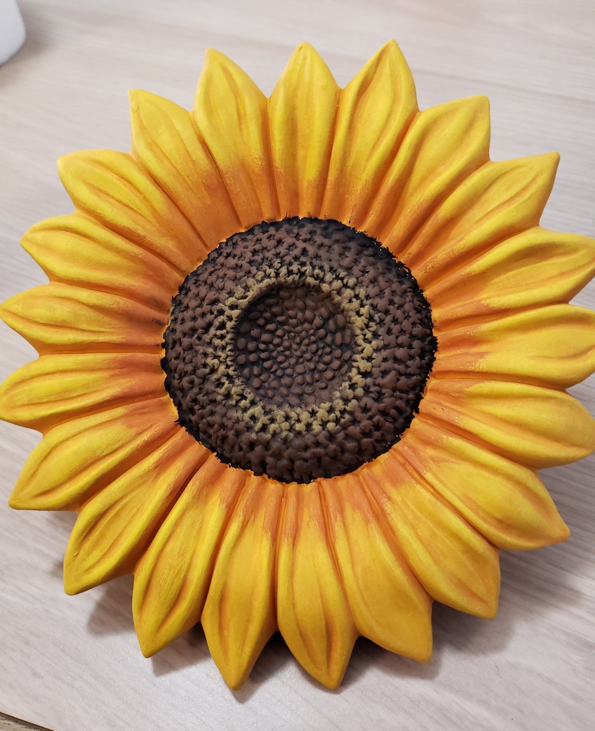 A large sunflower is sitting on a wooden table