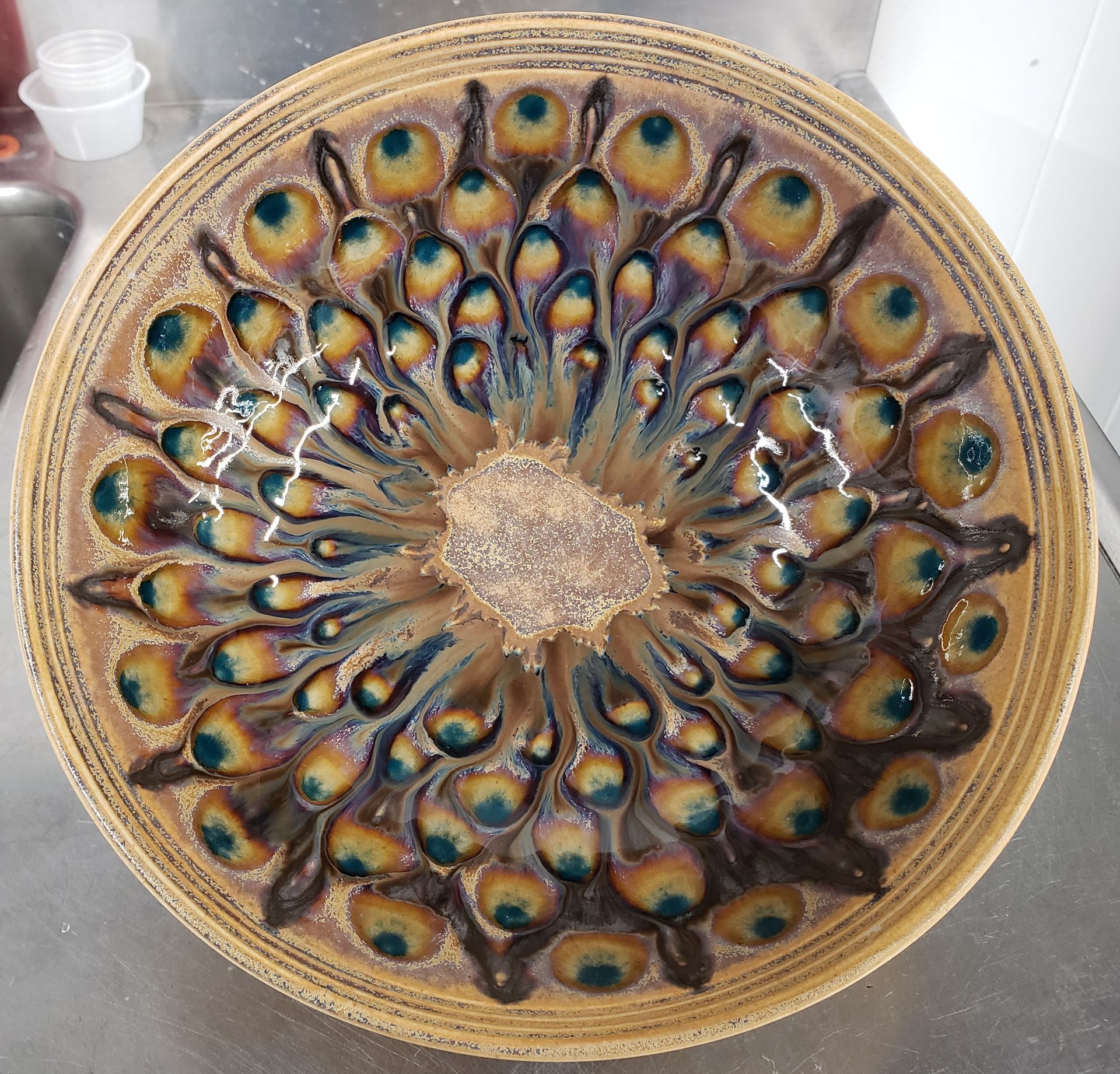 A plate with a peacock feather design on it