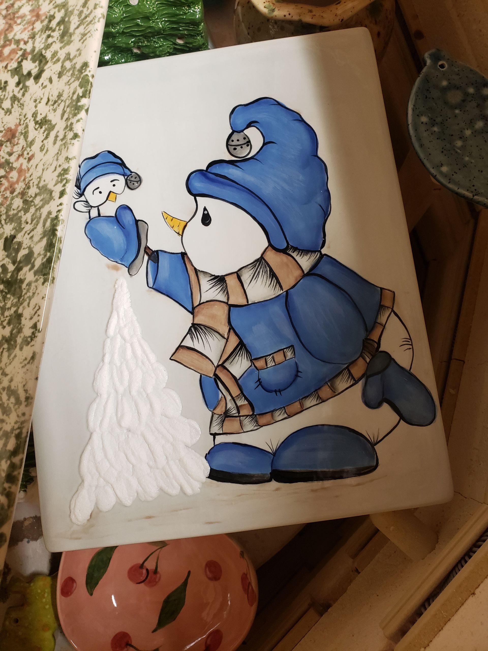 A painting of a snowman wearing a blue hat and scarf